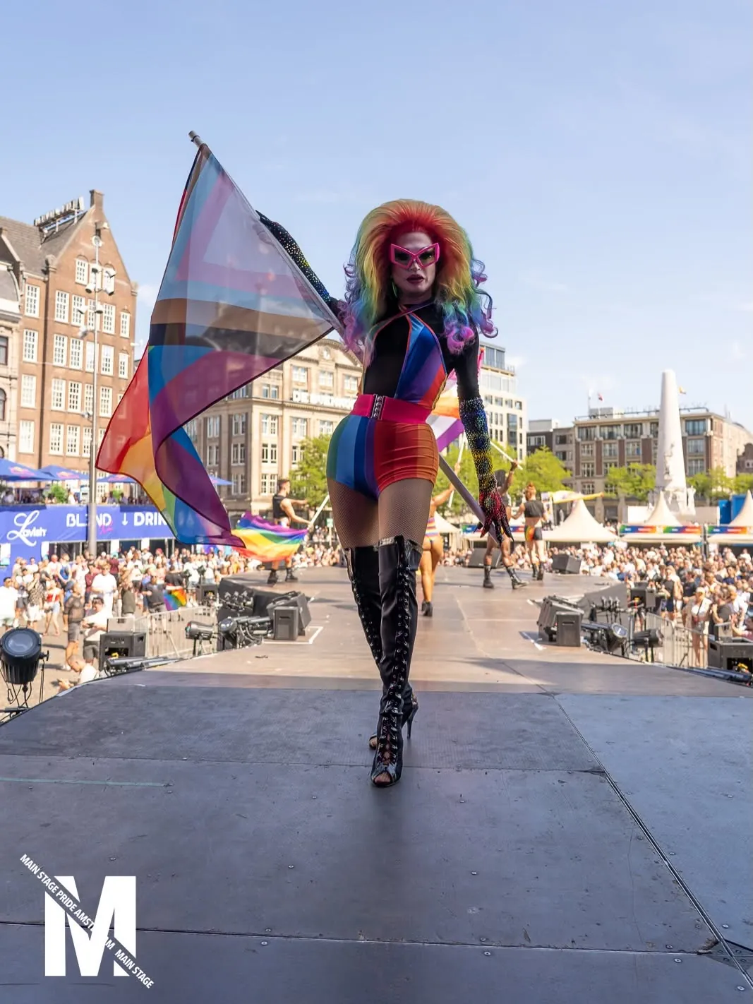 Performer in a rainbow bodysuit on the runway towards Dam Square, MainStage Pride Amsterdam 2026